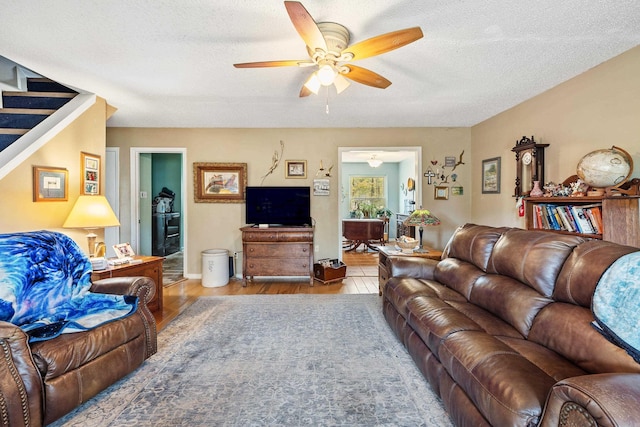 3613 Northlake Rd, Alexander, AR 72002 - living area featuring a textured ceiling, wood finished floors, stairs, and a ceiling fan