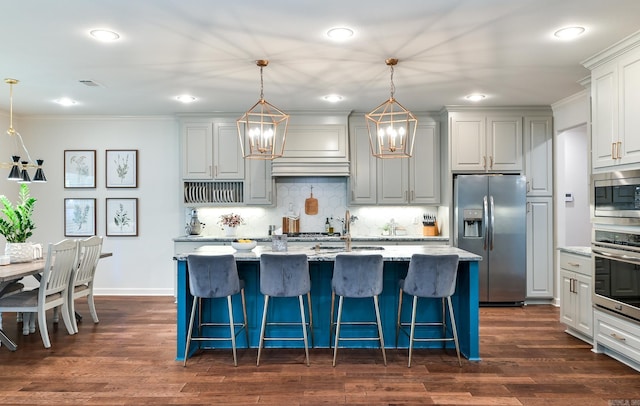 411 Sienna Lake Dr, Little Rock, AR 72210 - kitchen with light stone counters, dark wood-style floors, stainless steel appliances, a kitchen island with sink, and an inviting chandelier