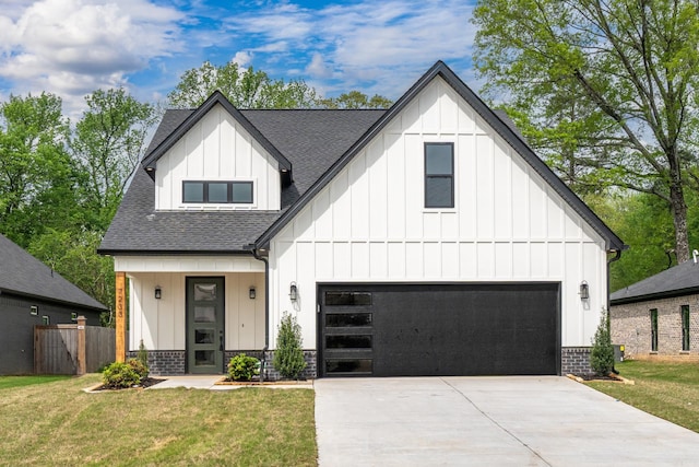 modern farmhouse style home with a garage, concrete driveway, a front yard, board and batten siding, and a shingled roof
