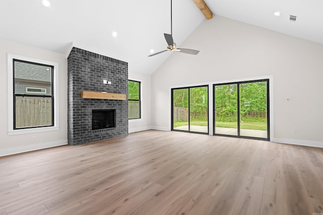 unfurnished living room with high vaulted ceiling, visible vents, beamed ceiling, light wood finished floors, and a ceiling fan