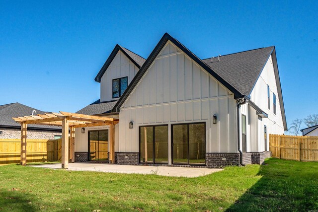 back of property with a pergola, brick siding, a patio area, and board and batten siding