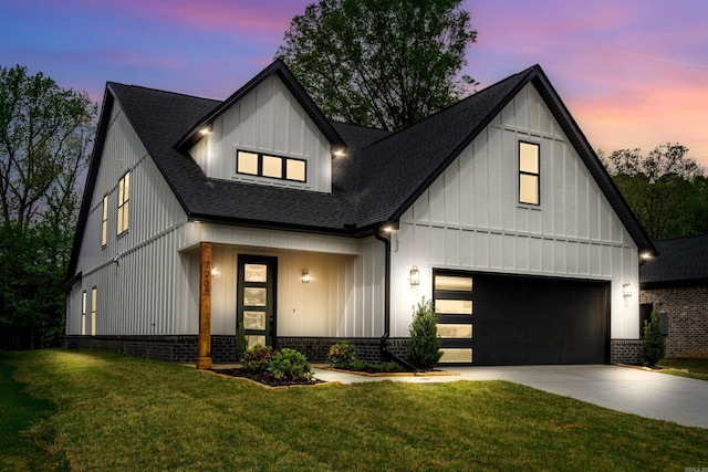 modern farmhouse with brick siding, board and batten siding, driveway, a shingled roof, and a yard