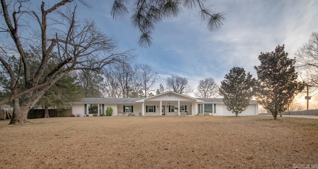 ranch-style home with a front lawn, a porch, and an attached garage