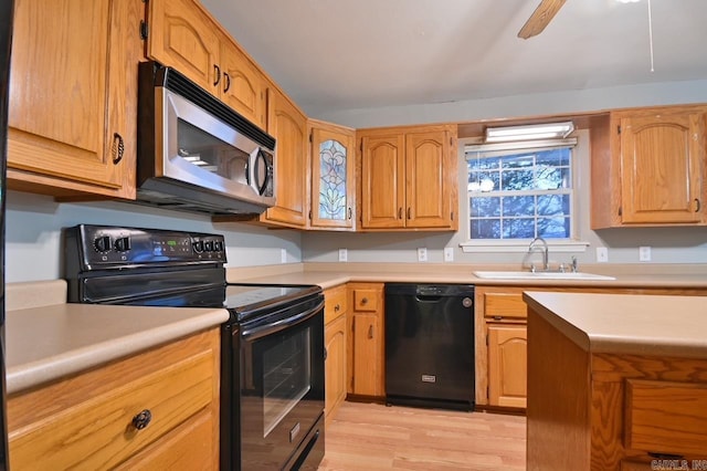 kitchen with light countertops, a sink, light wood-style floors, ceiling fan, and black appliances
