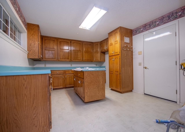 kitchen with a center island, brown cabinetry, and light floors