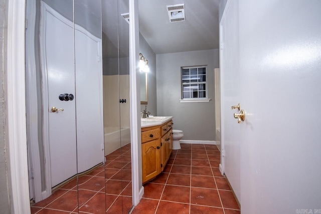 bathroom with tile patterned floors, toilet, vanity, baseboards, and visible vents