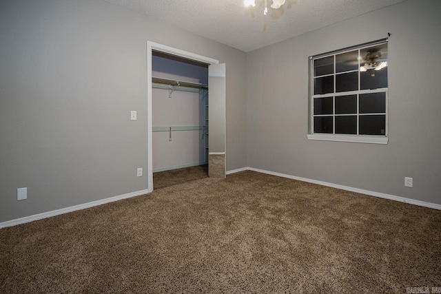 unfurnished bedroom with baseboards, a closet, carpet floors, and a textured ceiling