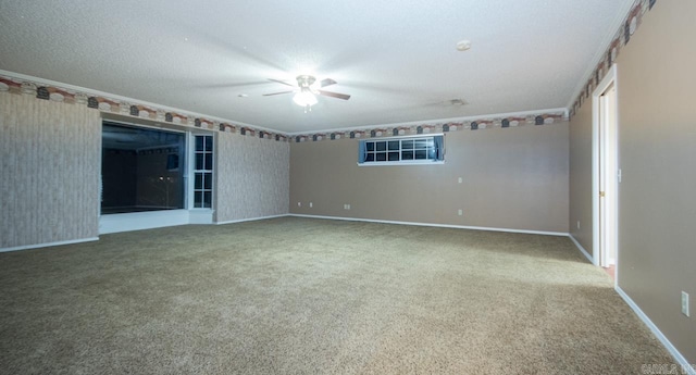 empty room with carpet flooring, a ceiling fan, ornamental molding, and baseboards