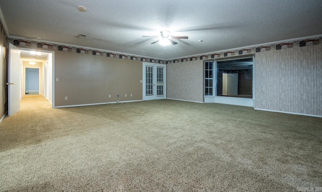 carpeted empty room featuring baseboards, a textured ceiling, a ceiling fan, and ornamental molding