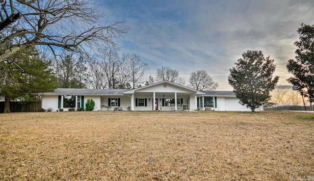 single story home featuring covered porch, fence, and a front lawn