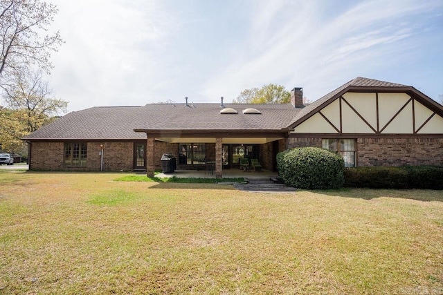 1110 Huntington Pl, Heber Springs, AR 72543 - back of property with brick siding, a lawn, a shingled roof, and a patio