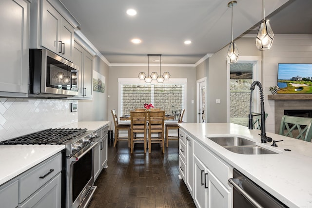 kitchen with dark wood-style flooring, stainless steel appliances, ornamental molding, backsplash, and a sink
