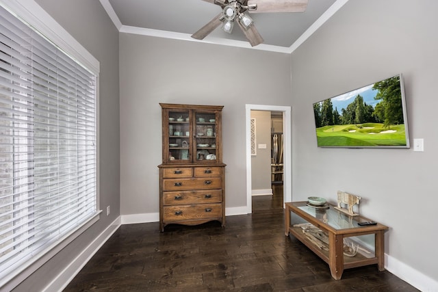 interior space with baseboards, crown molding, wood finished floors, and a ceiling fan