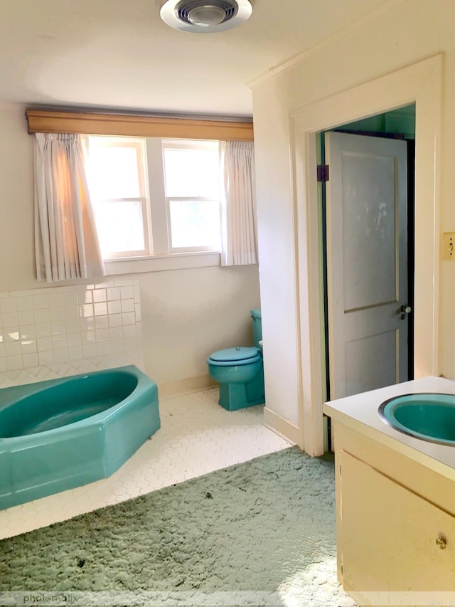 full bath with toilet, vanity, a bathtub, and baseboards