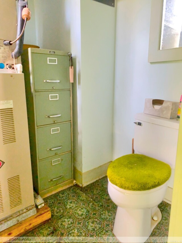 bathroom with baseboards and toilet