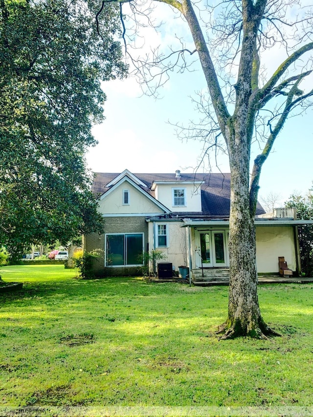 rear view of house featuring a yard