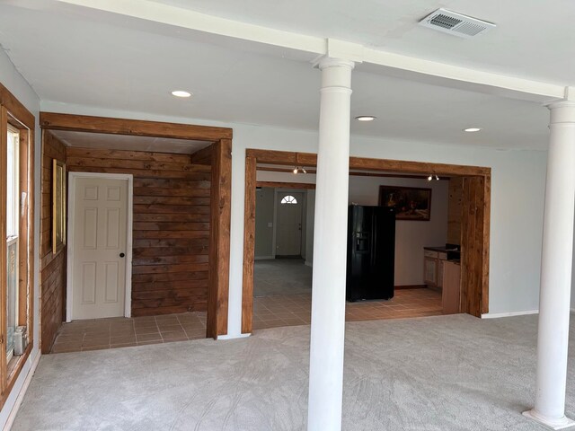 321 Forrest Dr, Newport, AR 72112 - interior space featuring carpet flooring, visible vents, black refrigerator with ice dispenser, and wood walls