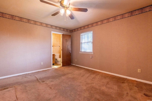 empty room featuring a ceiling fan, carpet, and baseboards