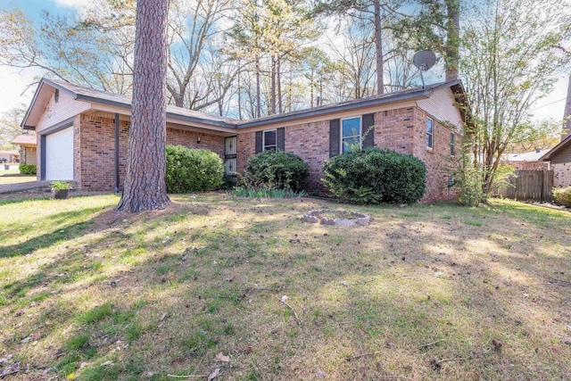 ranch-style house with brick siding, a garage, fence, and a front yard