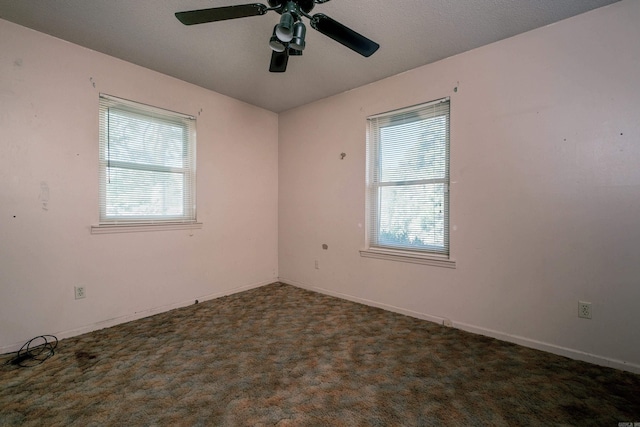 spare room with plenty of natural light, baseboards, ceiling fan, and carpet