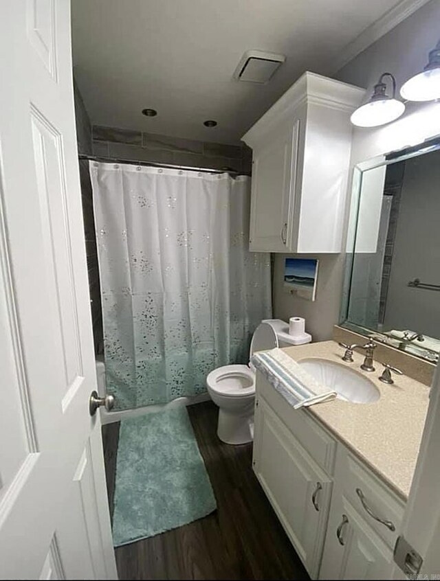 6 Timber Ridge Dr, Atlanta, TX 75551 - bathroom featuring toilet, vanity, wood finished floors, shower / bath combo with shower curtain, and visible vents