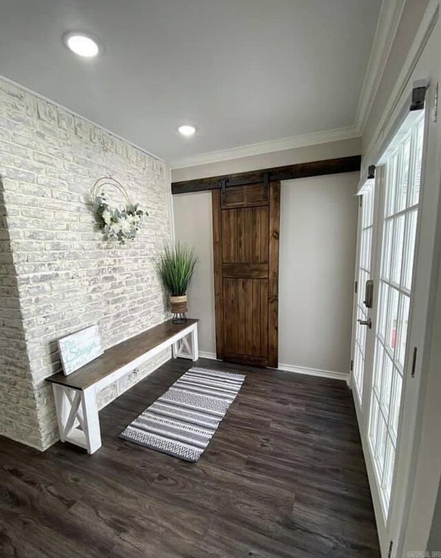 6 Timber Ridge Dr, Atlanta, TX 75551 - entrance foyer featuring crown molding, a barn door, wood finished floors, brick wall, and baseboards