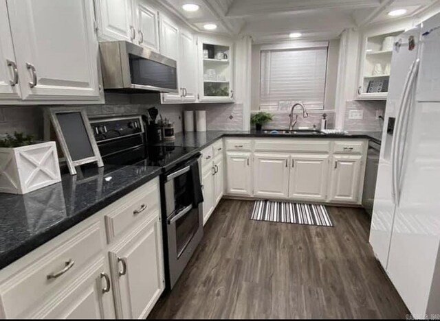 6 Timber Ridge Dr, Atlanta, TX 75551 - kitchen with dark wood-style flooring, stainless steel appliances, white cabinetry, a sink, and backsplash