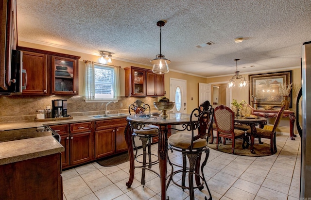 7200 Nell Dr, Pine Bluff, AR 71603 - kitchen featuring ornamental molding, decorative backsplash, light tile patterned flooring, a sink, and pendant lighting