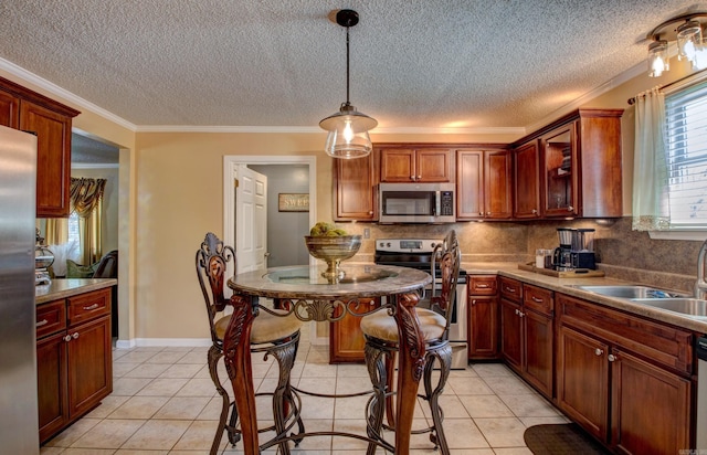 7200 Nell Dr, Pine Bluff, AR 71603 - kitchen featuring light tile patterned flooring, stainless steel appliances, tasteful backsplash, a sink, and hanging light fixtures