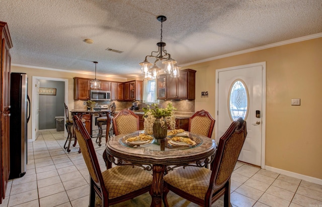 7200 Nell Dr, Pine Bluff, AR 71603 - dining space featuring crown molding, an inviting chandelier, baseboards, light tile patterned flooring, and visible vents