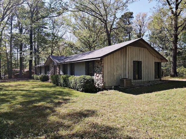 view of property exterior featuring board and batten siding, a yard, and central air condition unit