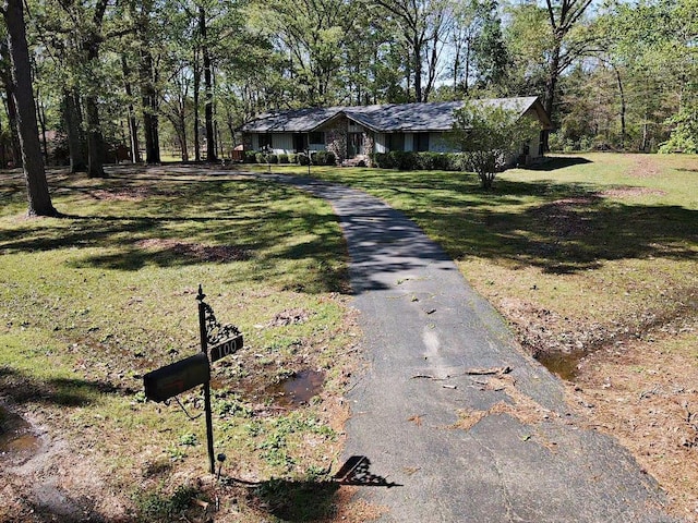 view of front of house with aphalt driveway and a front lawn