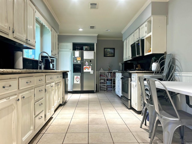 kitchen with light tile patterned floors, visible vents, ornamental molding, and appliances with stainless steel finishes