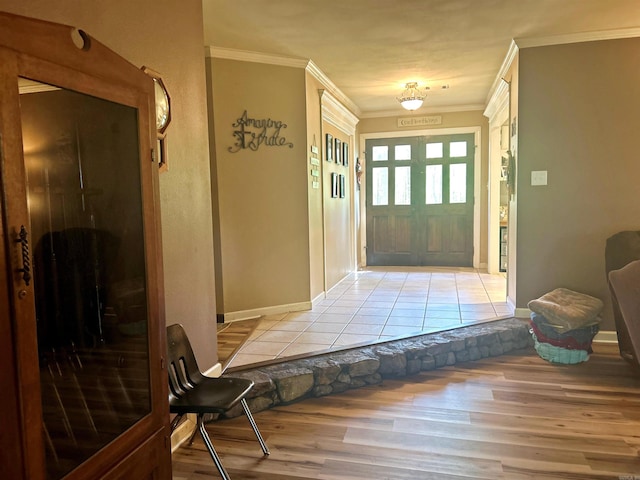 entrance foyer featuring crown molding, baseboards, and light wood-type flooring