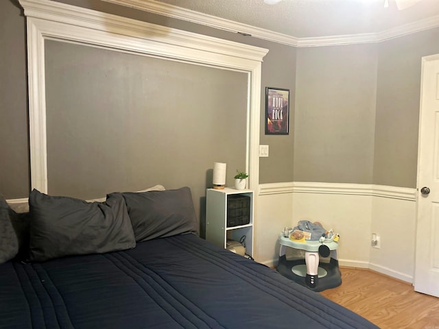 bedroom featuring crown molding, wood finished floors, and baseboards