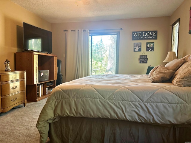 bedroom featuring light carpet and a textured ceiling