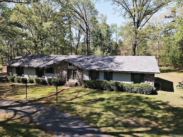 view of front of house featuring stone siding and a front lawn