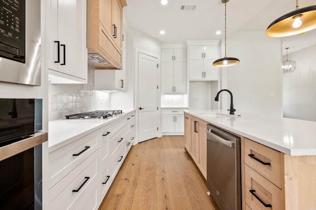 6172 Majestic Waters Dr, Alexander, AR 72002 - kitchen with appliances with stainless steel finishes, a sink, recessed lighting, light wood-style floors, and backsplash