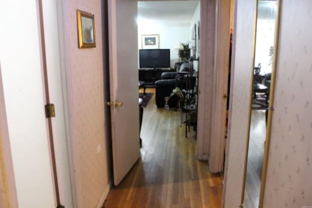 hall featuring wallpapered walls and light wood-type flooring