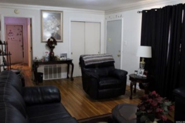 living room featuring crown molding and wood finished floors