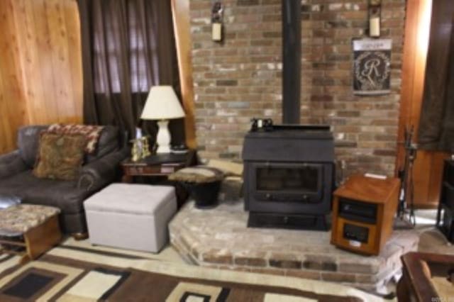 living room with wood walls and a wood stove