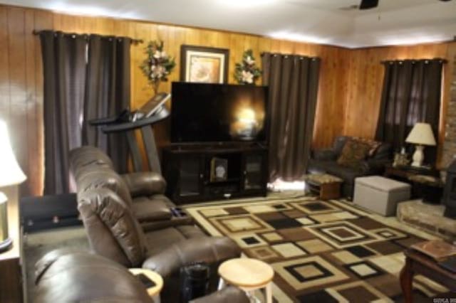living room with ceiling fan and wooden walls
