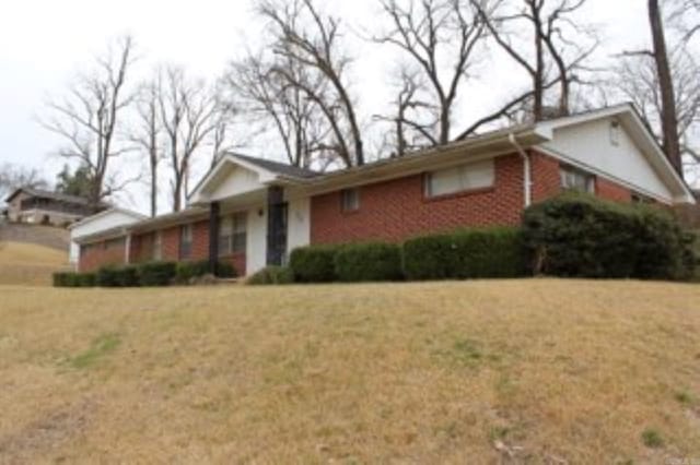ranch-style house with brick siding and a front yard