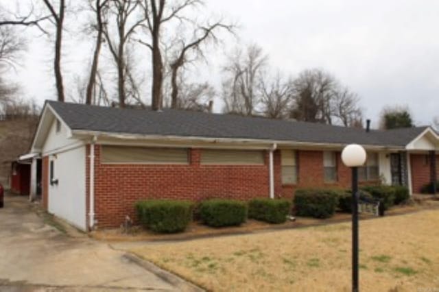 ranch-style house featuring driveway and brick siding