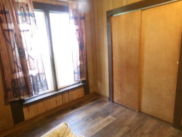 405 S Skaggs Rd, Clarksville, AR 72830 - unfurnished bedroom with wood walls, a closet, and wood finished floors