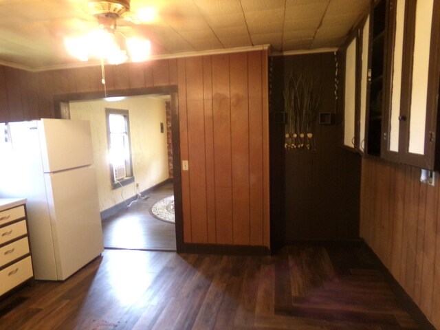 405 S Skaggs Rd, Clarksville, AR 72830 - kitchen with crown molding, freestanding refrigerator, ceiling fan, dark wood-type flooring, and wood walls
