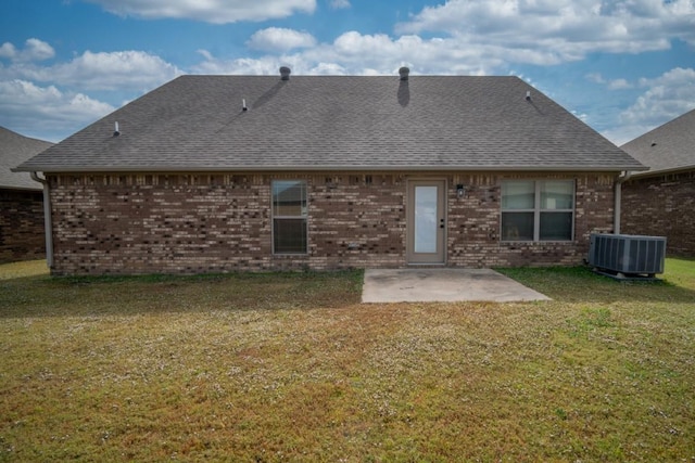 back of house featuring a patio, a lawn, central AC unit, brick siding, and a shingled roof