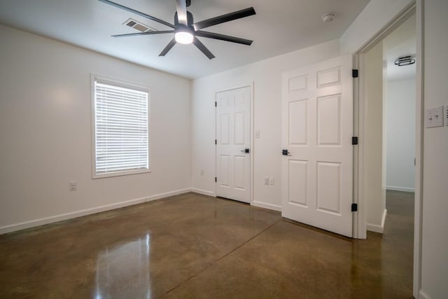 unfurnished bedroom featuring concrete flooring, visible vents, baseboards, and ceiling fan