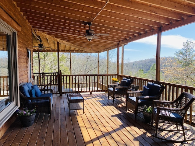 wooden terrace with an outdoor living space and a ceiling fan