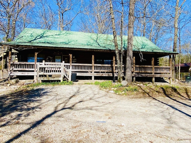 cabin featuring a porch and metal roof